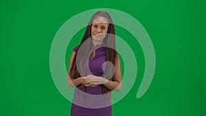 Female reporter isolated on chroma key green screen background. African American woman news host in dress looking at the