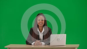 Female reporter isolated on chroma key green screen background. African American woman news host in suit at the desk