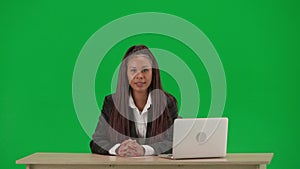 Female reporter isolated on chroma key green screen background. African American woman news host in suit at the desk