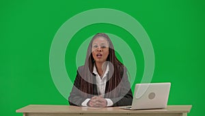 Female reporter isolated on chroma key green screen background. African American woman news host in suit at the desk