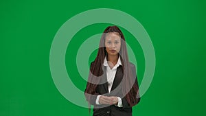 Female reporter isolated on chroma key green screen background. African American woman news host in suit looking at the
