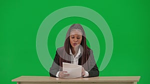 Female reporter isolated on chroma key green screen background. African American woman news host in suit reading