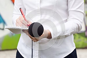 Female reporter or journalist at press conference, writing notes