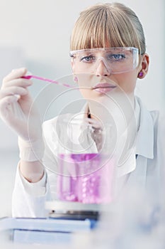 Female researcher holding up a test tube in lab