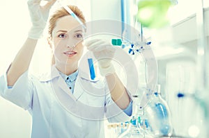 Female researcher mixing chemical liquids in lab