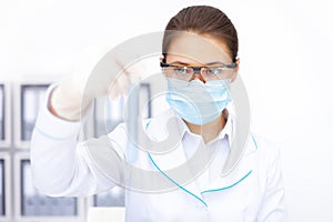 Female researcher observing liquid in flask