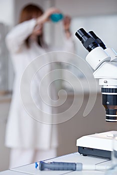 Female researcher using a microscope in a lab