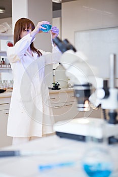 Female researcher using a microscope in a lab