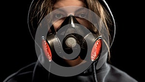 Female in respirator on dark background, protection from gas attack, closeup