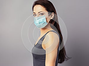 Female in respiratory blue mask. Masked serious woman looking on camera. Cold, flu, virus, tonsillitis, respiratory disease,