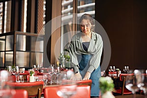 Female restaurant owner setting tables