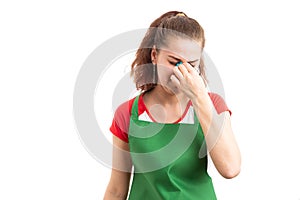 Female retail storekeeper or worker suffering head pain photo
