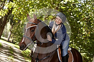 Female rider caressing horse