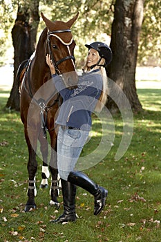 Female rider embracing horse