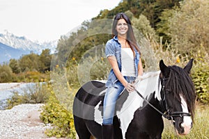 Female rider sitting on her horse and smiling