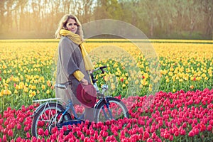 Female riding her bike through tulip fields