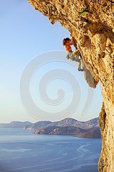 Female rock climber on challenging route on cliff