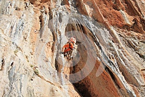 Female rock climber on handholds on challenging route on cliff