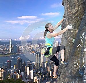 Female rock climber over the city skyline