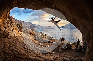 Female rock climber posing while climbing