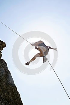 Female Rock Climber Rappelling