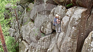 Female rock climber training rock climbing on a huge boulder