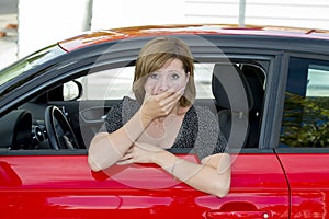 Female rookie new driver young beautiful woman scared and stressed while driving car in fear and shock photo