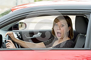 Female rookie new driver young beautiful woman scared and stressed while driving car in fear and shock photo