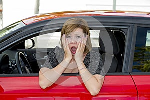 Female rookie new driver young beautiful woman scared and stressed while driving car in fear and shock photo