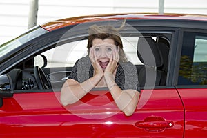 Female rookie new driver young beautiful woman scared and stressed while driving car in fear and shock photo