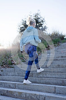 Female runner athlete going up stairs in urban city doing cardio sport workout run outside