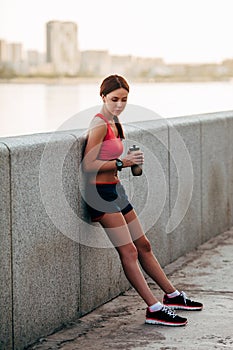 Female runner with bottled water tired