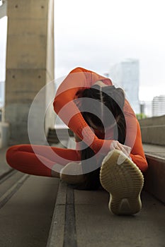 Female runner doing stretching exercise. Vertical image. Woman morning workout routine