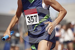 Female runner finalizing a relay race in a running track