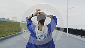 Female runner getting ready to run and tying her hair