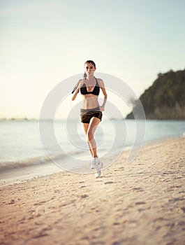 Female runner jogging during outdoor workout on beach