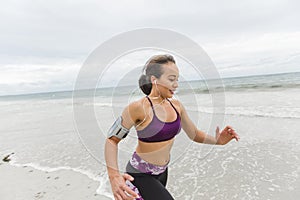 Female runner jogging during outdoor workout on the beach