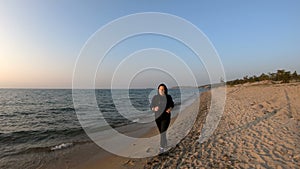 Female runner jogging on the sandy beach at sunset