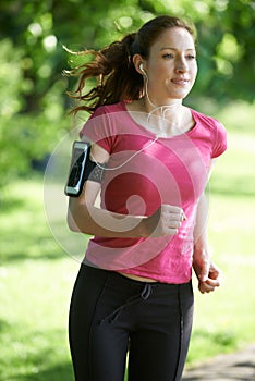 Female Runner In Park With Wearable Technology