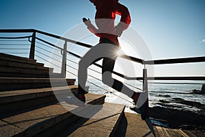 female runner running upstairs on coast trail