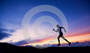 Female runner silhouette, running into sunset