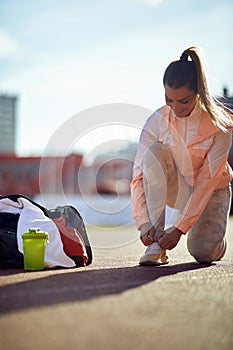 Female runner in sportswear prepare for training on stadium