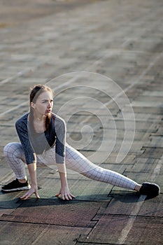 Female runner stretching legs on running track