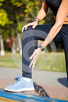 Female runner touching cramped calf at jogging