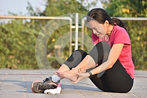 Female runner touching foot in pain due to sprained ankle