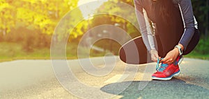 Female runner tying her shoes preparing for a jog