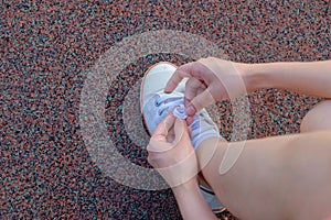 Female runner tying her sport shoe