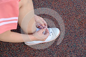 Female runner tying her sport shoe