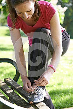 Female Runner Wearing Activity Band Tying Trainers