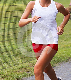 Female runner in white and red uniform racing